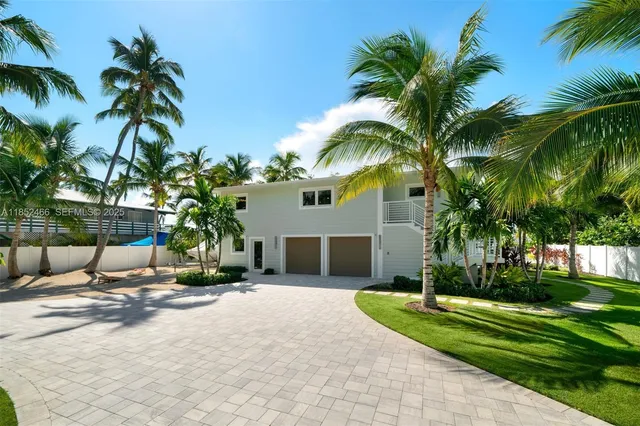 a view of a house with a yard and palm trees