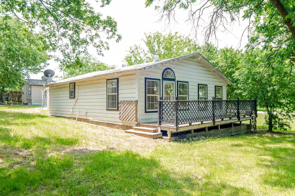 a view of a house with a backyard and a wooden deck
