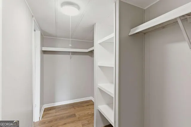a view of walk in closet with empty racks