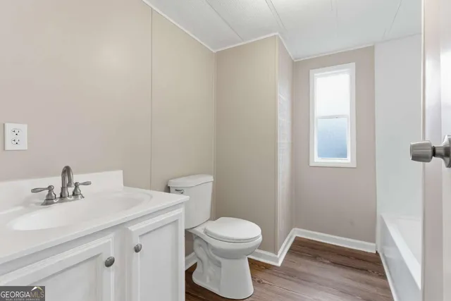 a bathroom with a toilet a sink and mirror