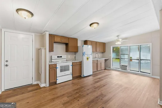 a kitchen with stainless steel appliances a stove top oven a sink and a refrigerator