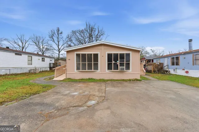 a view of a house with backyard and sitting area