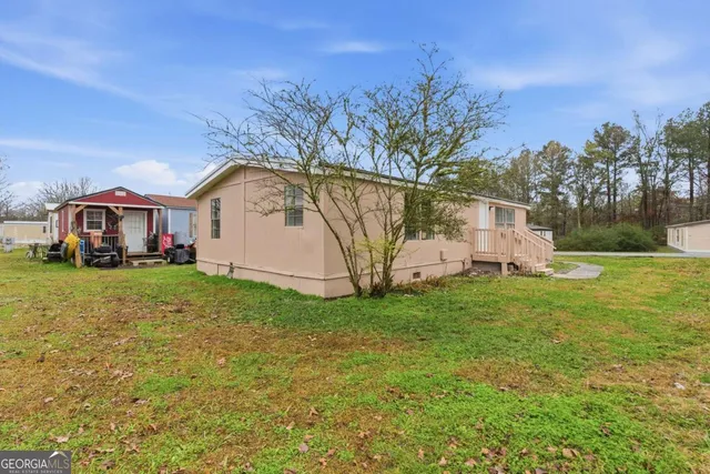 a front view of house with yard and trees in the background