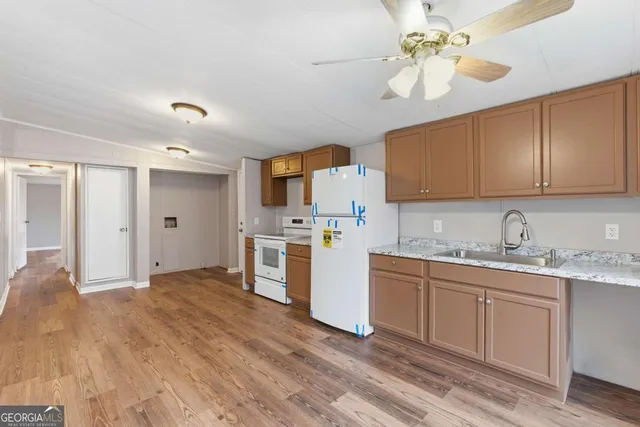 a kitchen with stainless steel appliances granite countertop a sink cabinets and wooden floor