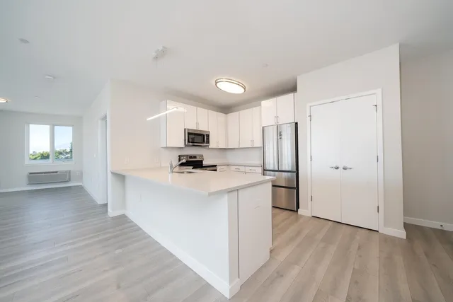 a kitchen with stainless steel appliances a refrigerator and a stove top oven