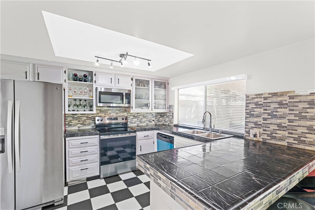 2130 Spice Street Lancaster, CA 93536 - Photo 13 of 45 a kitchen with stainless steel appliances granite countertop a stove a sink and a refrigerator
