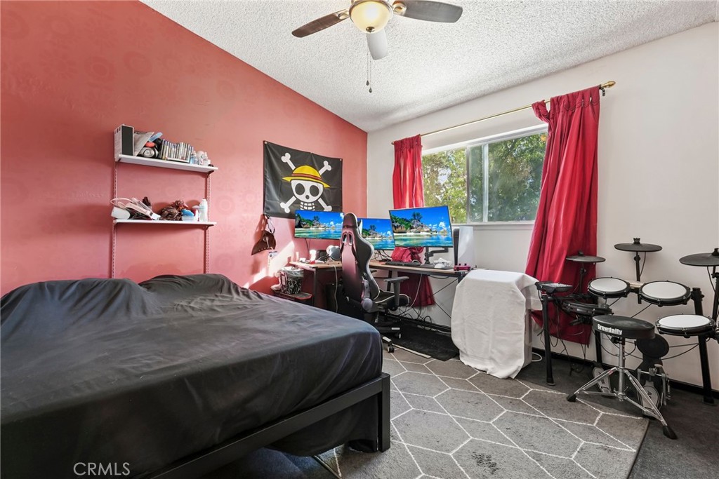 2130 Spice Street Lancaster, CA 93536 - Photo 23 of 45 a bedroom with a bed a large window and a chandelier