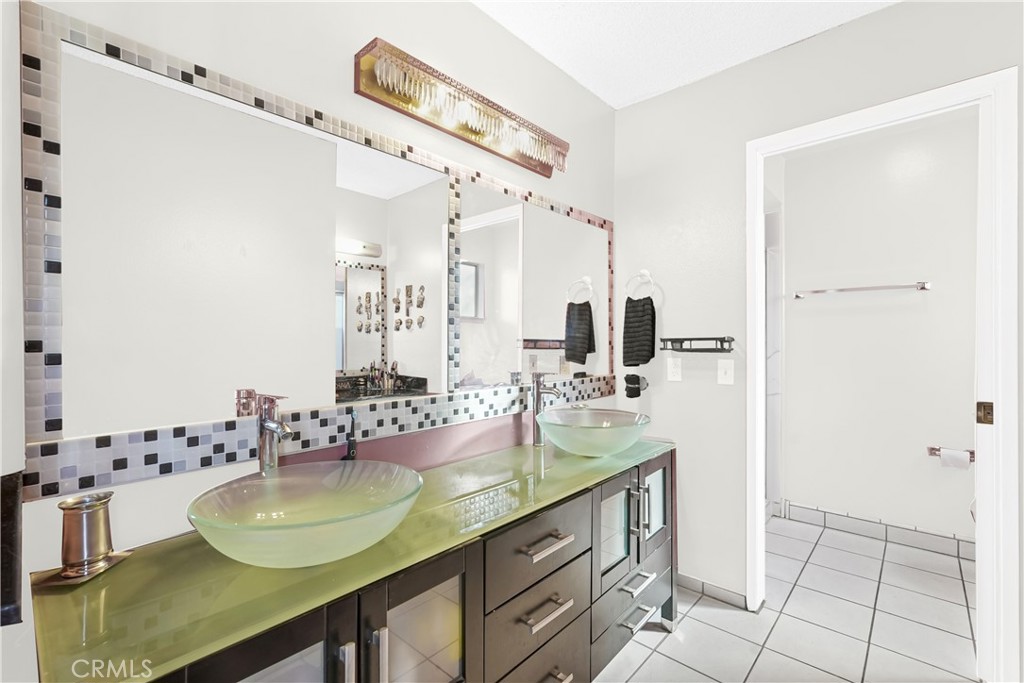 2130 Spice Street Lancaster, CA 93536 - Photo 33 of 45 a bathroom with a granite countertop sink a mirror and shower