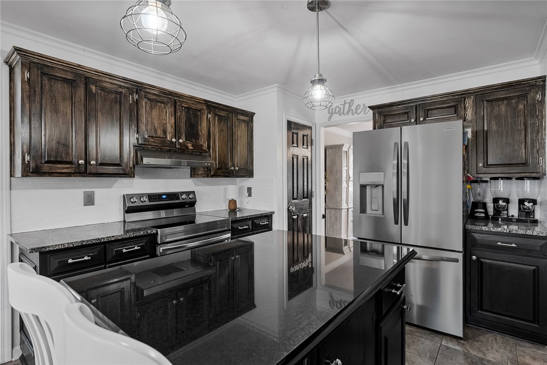 112 C-10-220 Anderson, SC 29621 - Photo 16 of 45 This contemporary kitchen features elegant dark cabinetry and sleek granite countertops, perfect for culinary endeavors.