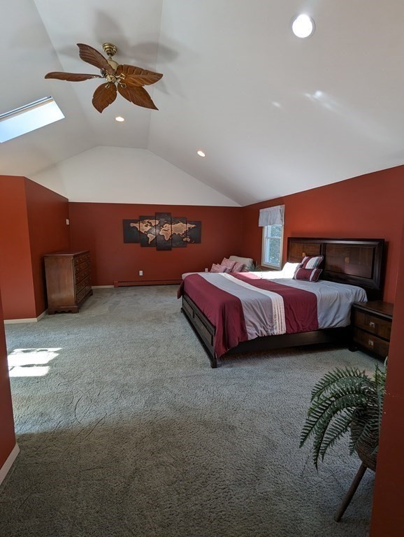 142 Clay Pond Road Bourne, MA 02532 - Photo 11 of 42 a spacious bedroom with a bed and a chandelier