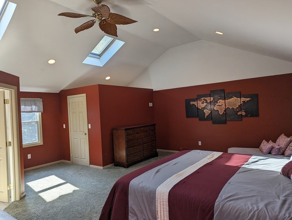 142 Clay Pond Road Bourne, MA 02532 - Photo 12 of 42 a bedroom with a large bed and a chandelier
