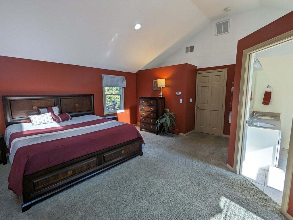 142 Clay Pond Road Bourne, MA 02532 - Photo 14 of 42 a bedroom with a bed and a large mirror