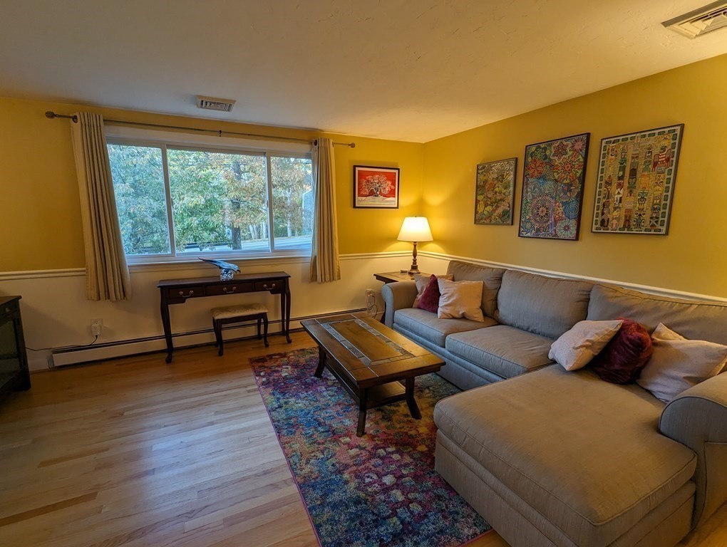 142 Clay Pond Road Bourne, MA 02532 - Photo 34 of 42 a living room with furniture and a floor to ceiling window