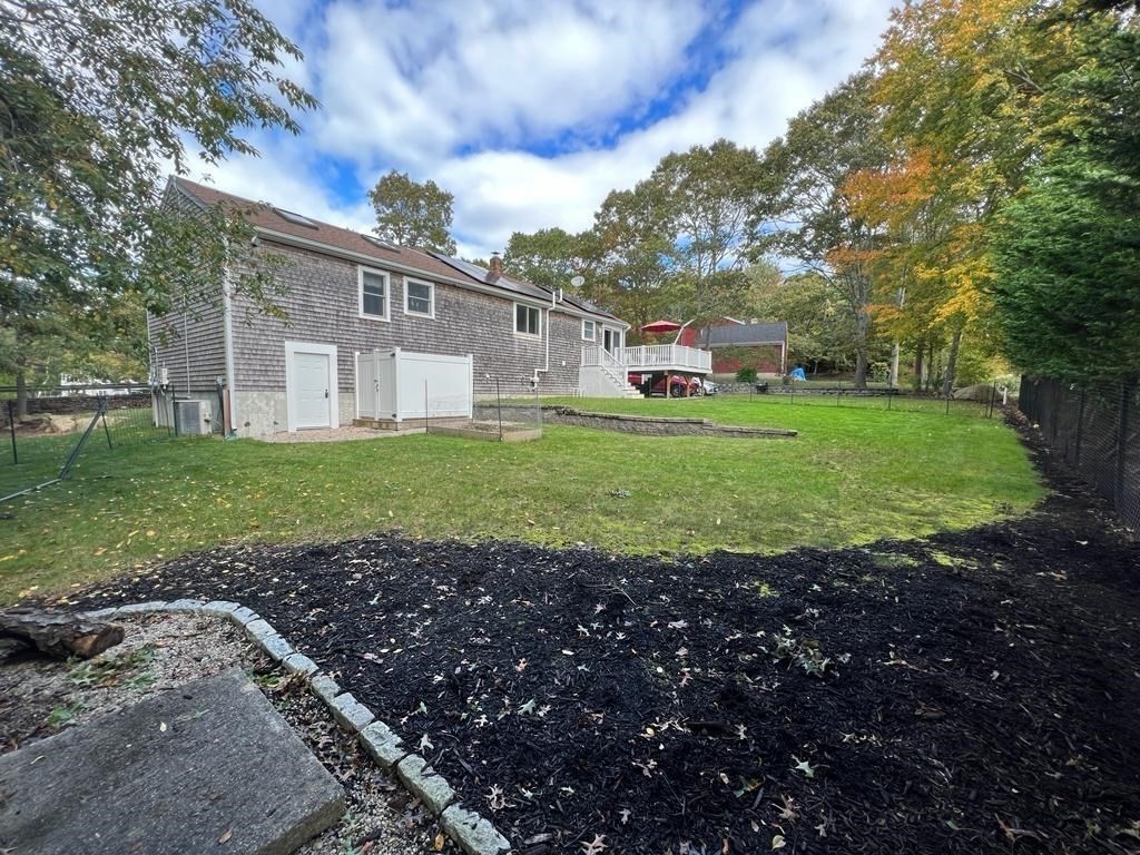 142 Clay Pond Road Bourne, MA 02532 - Photo 5 of 42 a front view of a house with a garden