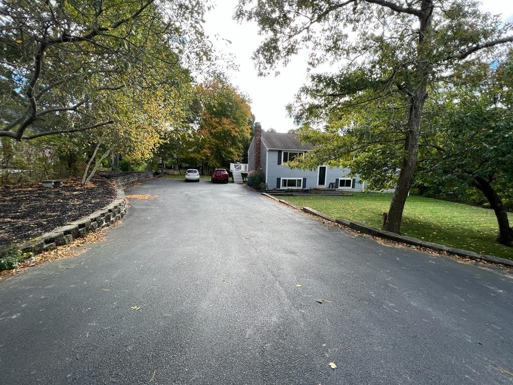 142 Clay Pond Road Bourne, MA 02532 - Photo 6 of 42 a view of a street with a building and trees in the background