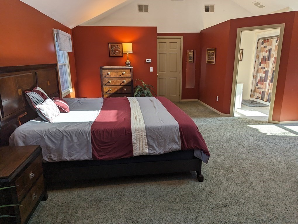 142 Clay Pond Road Bourne, MA 02532 - Photo 10 of 42 a bedroom with a bed and closet with mirror