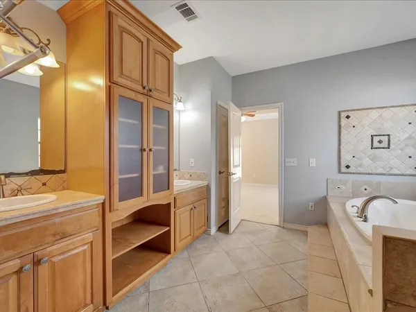 a bathroom with a tub sink and mirror