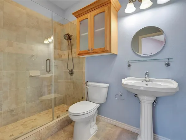 a bathroom with a sink a mirror a toilet and shower