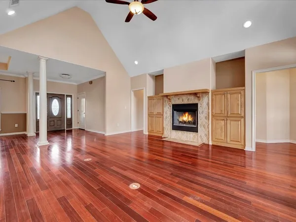 a view of a livingroom with wooden floor and a fireplace