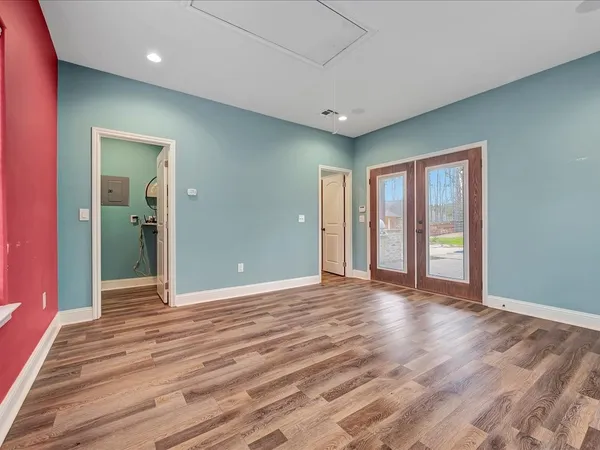 a view of an empty room with window and wooden floor