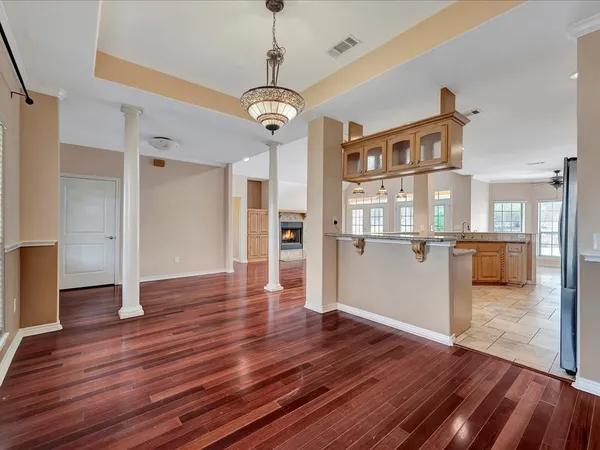 a view of a big room with wooden floor and a kitchen