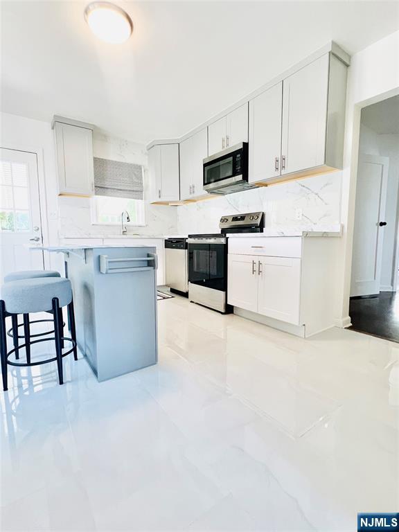 18 Pershing Street Garfield, NJ 07026 - Photo 7 of 16 a large white kitchen with cabinets