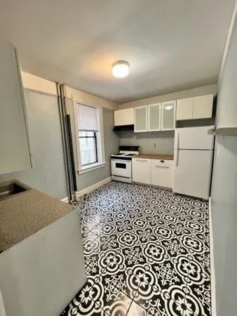 a living room with a couch and a stove next to a window