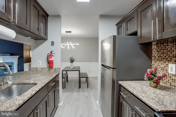 a kitchen with granite countertop a sink stainless steel appliances and cabinets