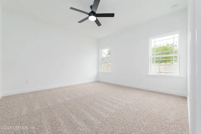 an empty room with a window and a fan
