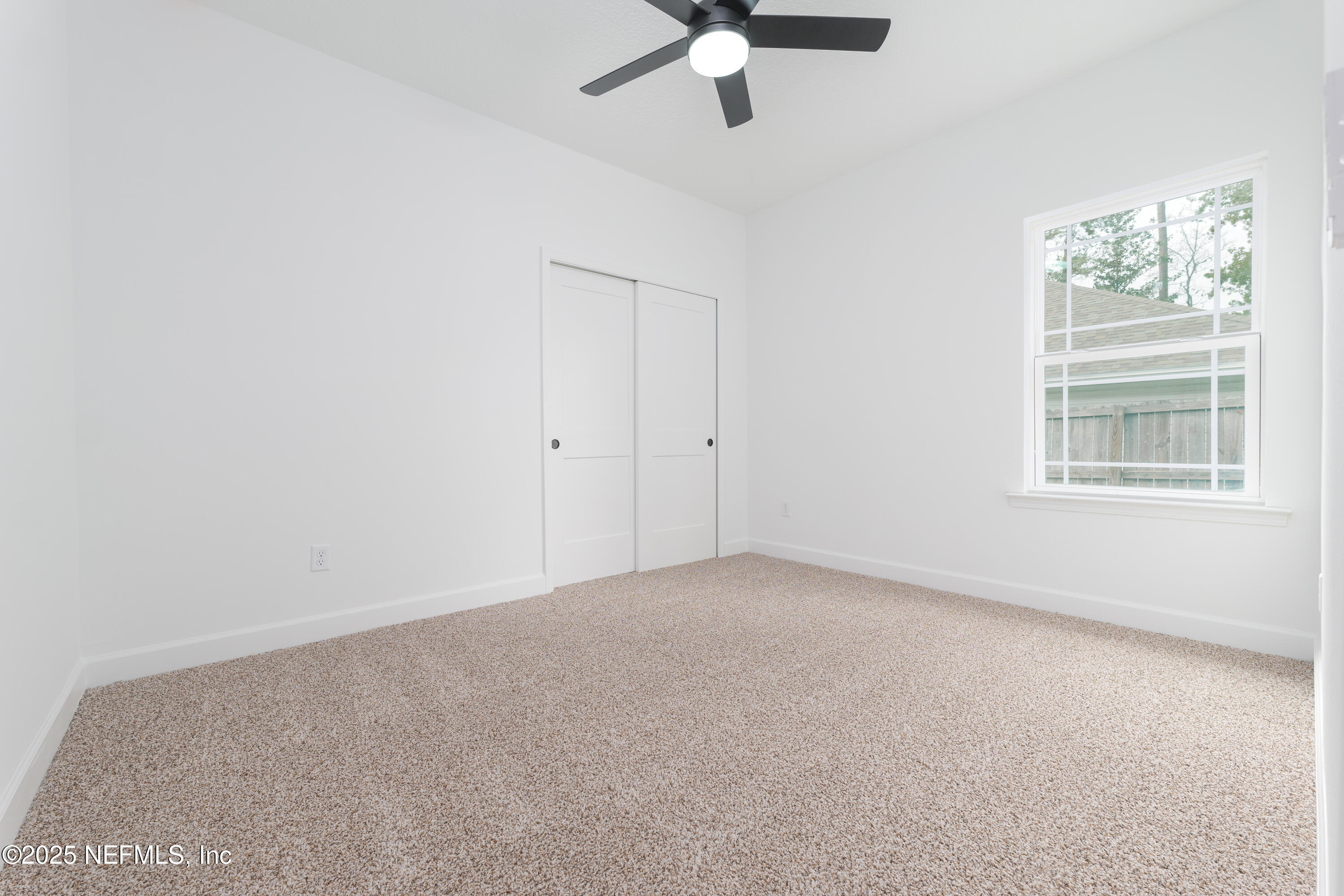 7596 Silver Sands Road Keystone Heights, FL 32656 - Photo 17 of 26 an empty room with windows and fan