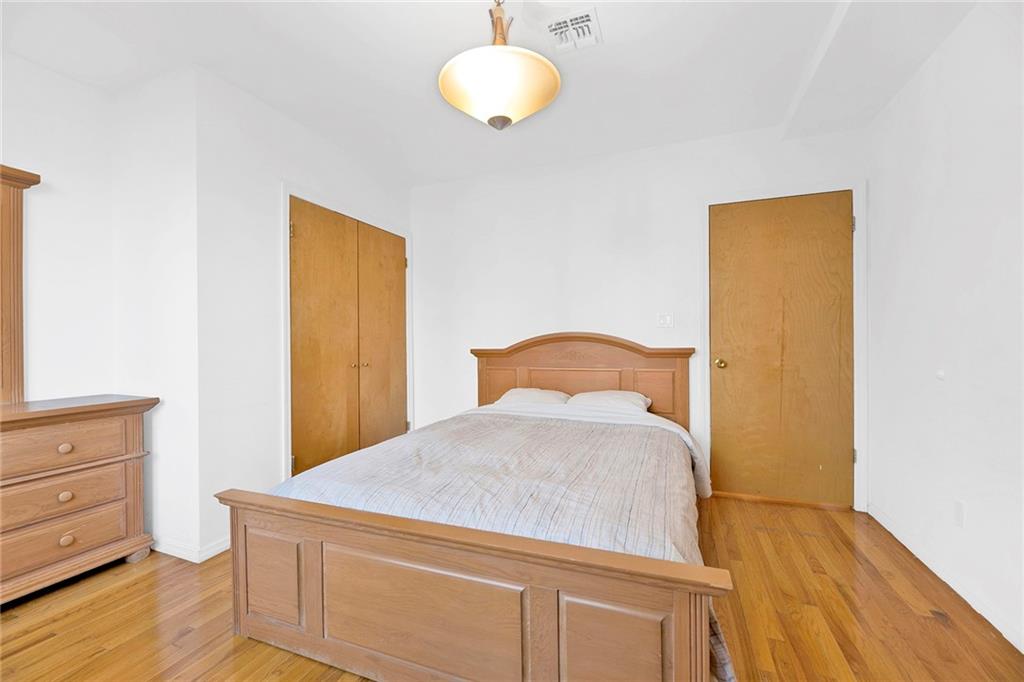 202 Quentin Road, Unit 2B Brooklyn, NY 11223 - Photo 11 of 16 a bedroom with a bed and wooden floor