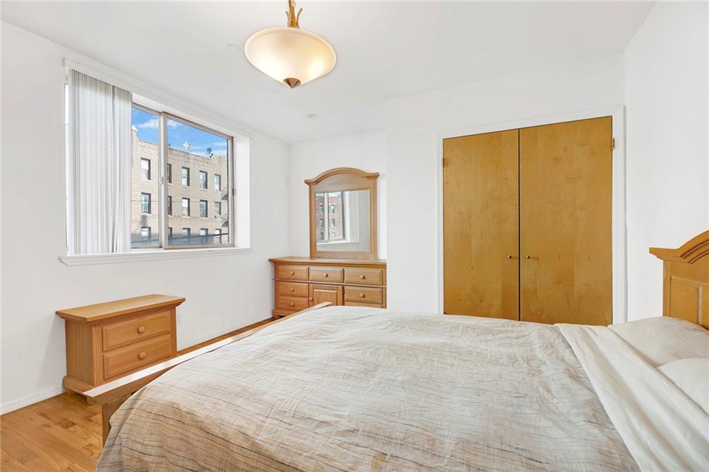 202 Quentin Road, Unit 2B Brooklyn, NY 11223 - Photo 16 of 16 a bedroom with a large bed and a chandelier