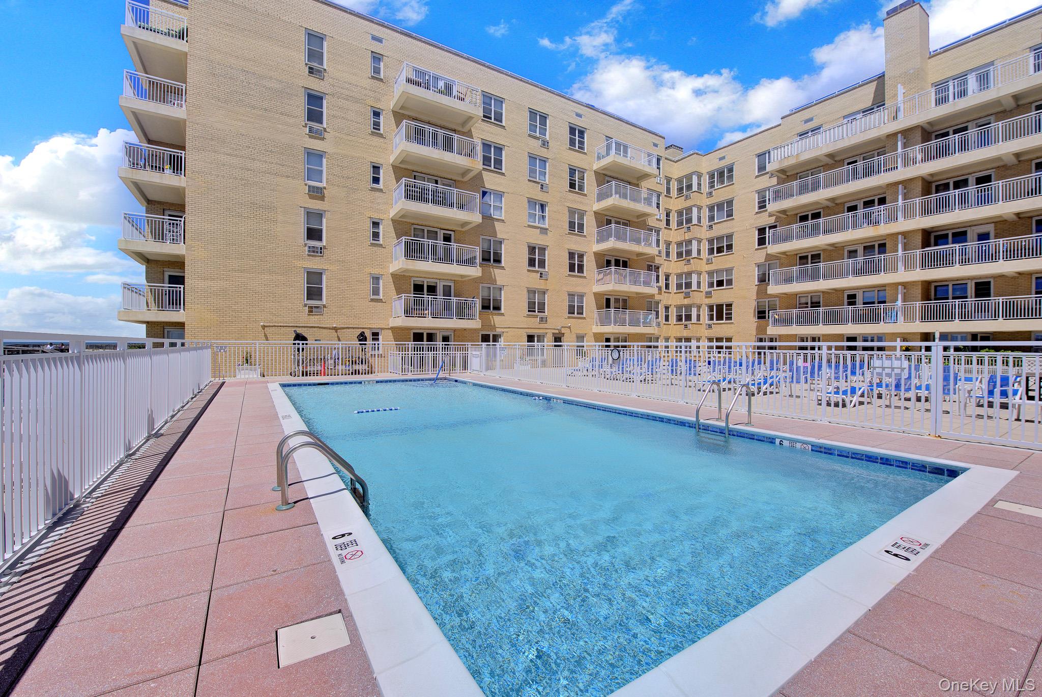 700 Shore Road, Unit 5M Long Beach, NY 11561 - Photo 26 of 34 View 1 Of Heated Salt Water Swimming Pool. And Rear View Of Pool Deck And Building.