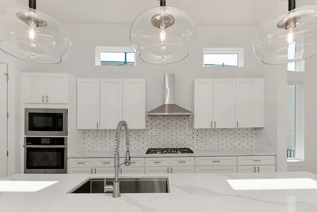 a kitchen with stainless steel appliances a stove a sink and a microwave