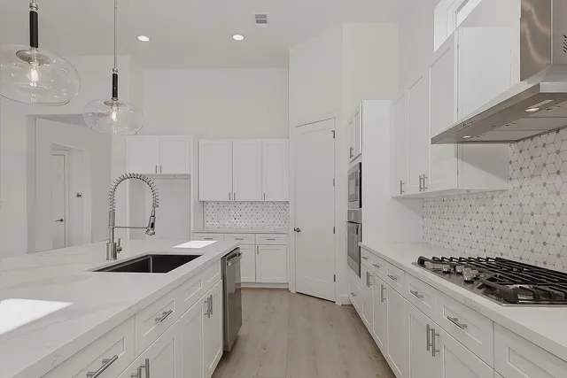 a kitchen with white cabinets stainless steel appliances and sink