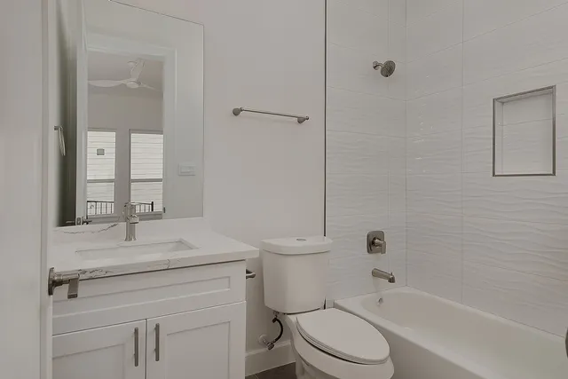 a bathroom with a sink toilet vanity and shower