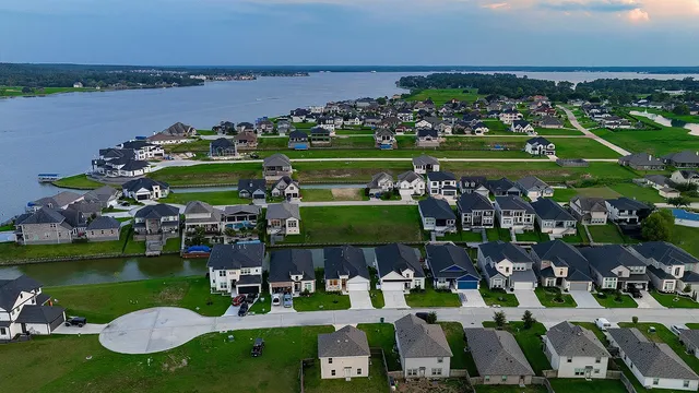 an aerial view of a house with a garden and lake view