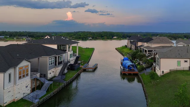 an aerial view of a house with outdoor space and lake view in back