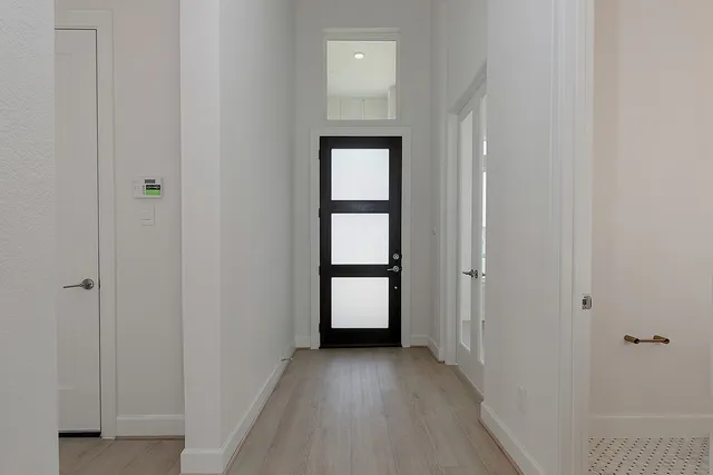 a view of an empty room with wooden floor and closet