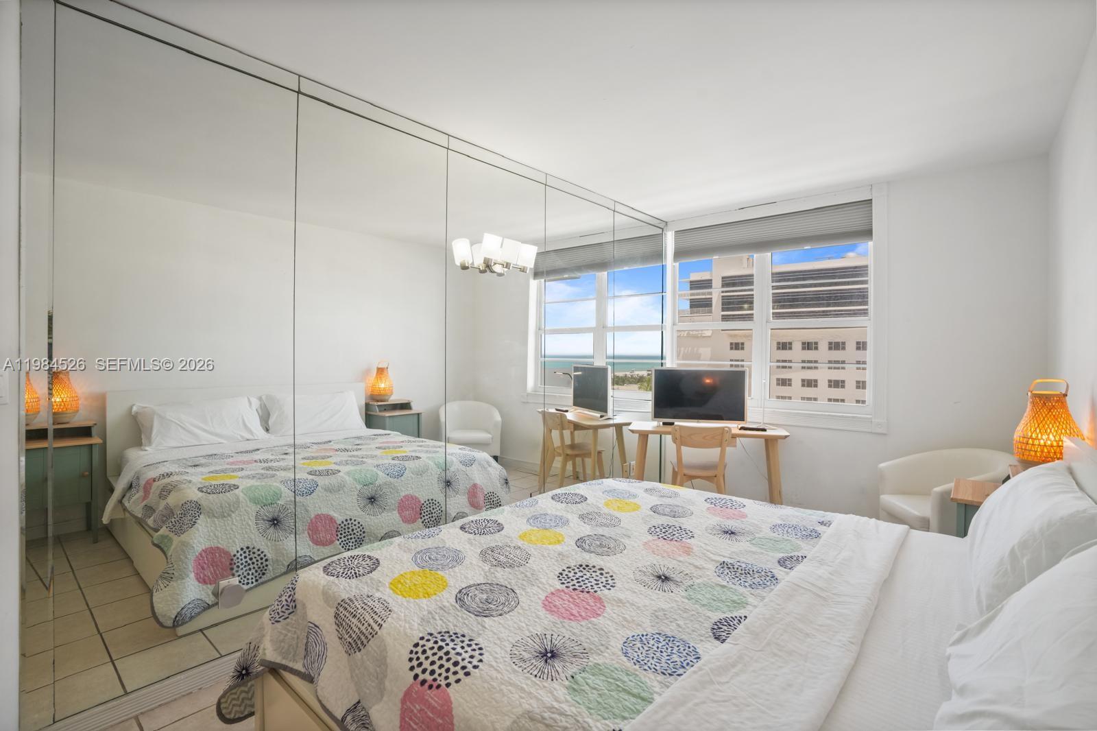 100 Lincoln Road, Unit 825 Miami Beach, FL 33139 - Photo 16 of 51 a bedroom with a bed and a table in it