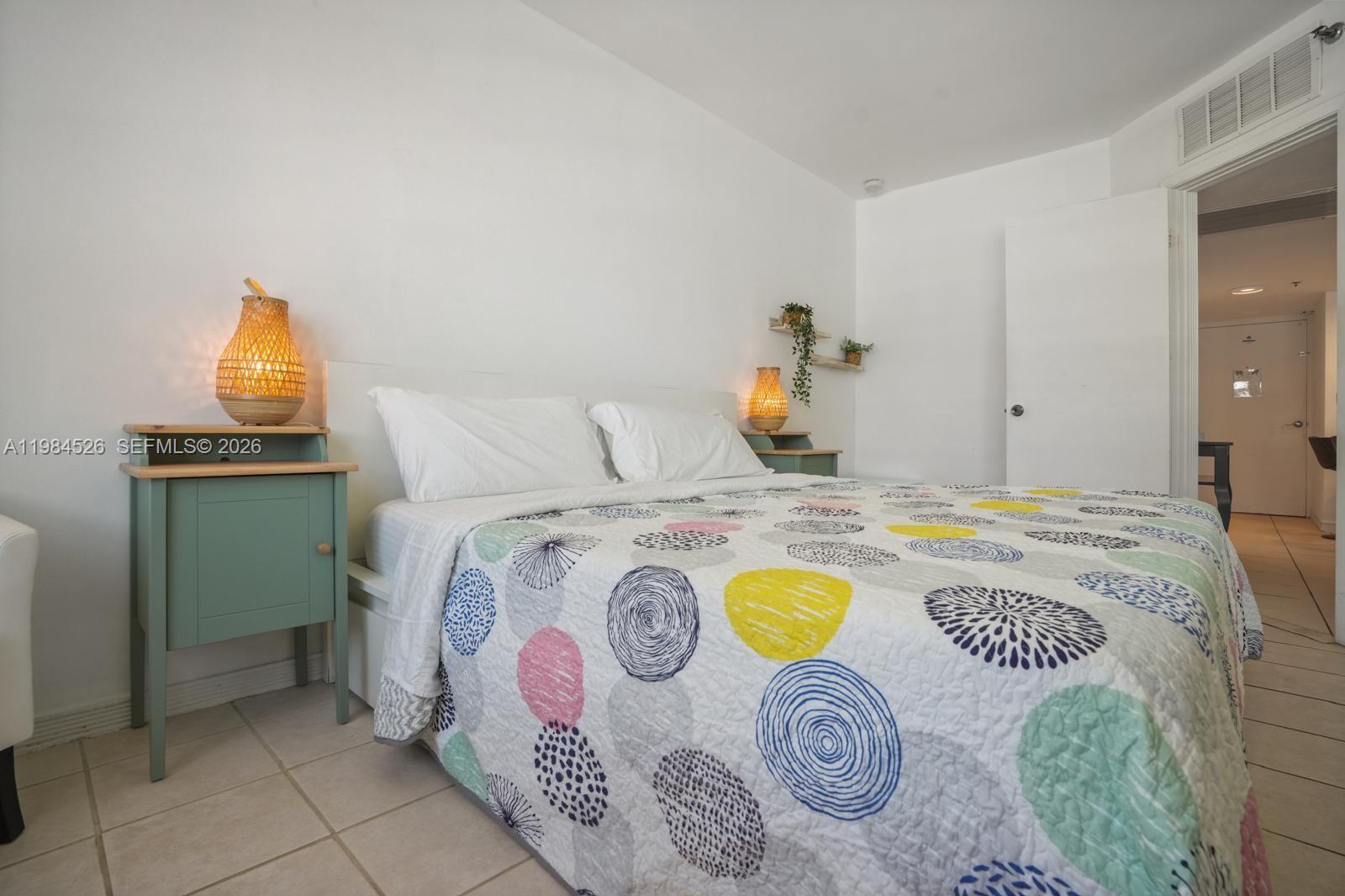 100 Lincoln Road, Unit 825 Miami Beach, FL 33139 - Photo 17 of 51 a bedroom with a bed and a table