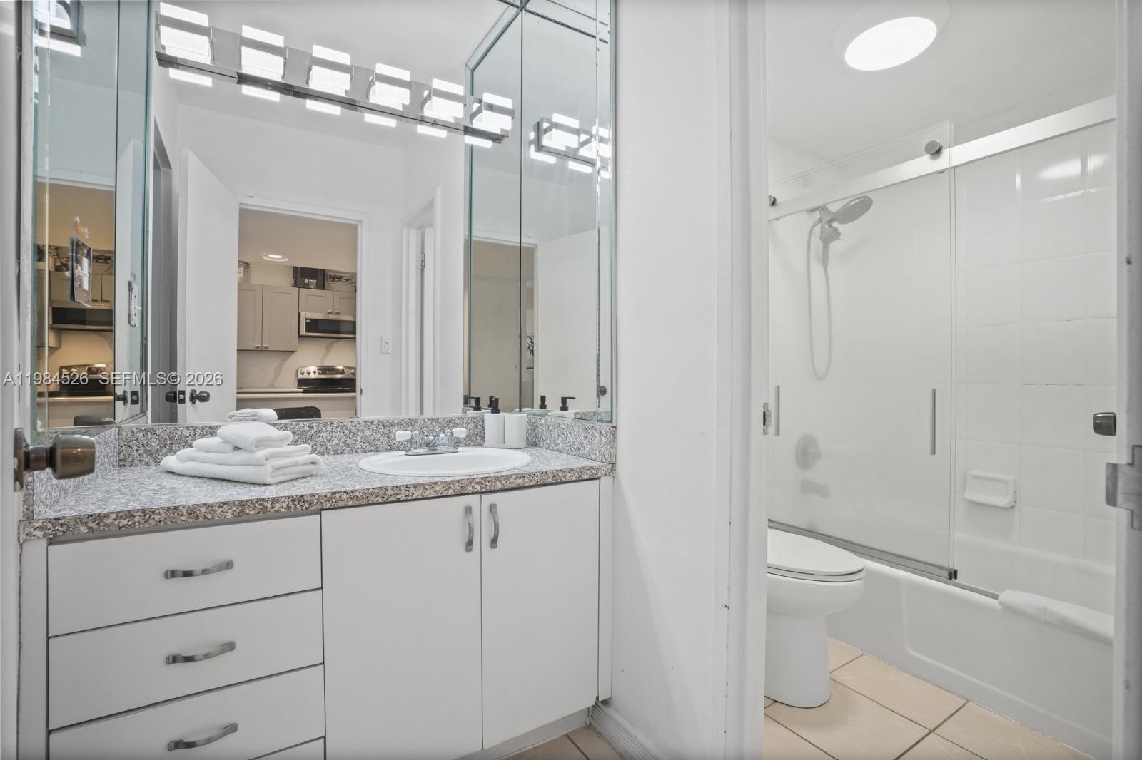 100 Lincoln Road, Unit 825 Miami Beach, FL 33139 - Photo 21 of 51 a bathroom with a granite countertop sink a toilet mirror and shower