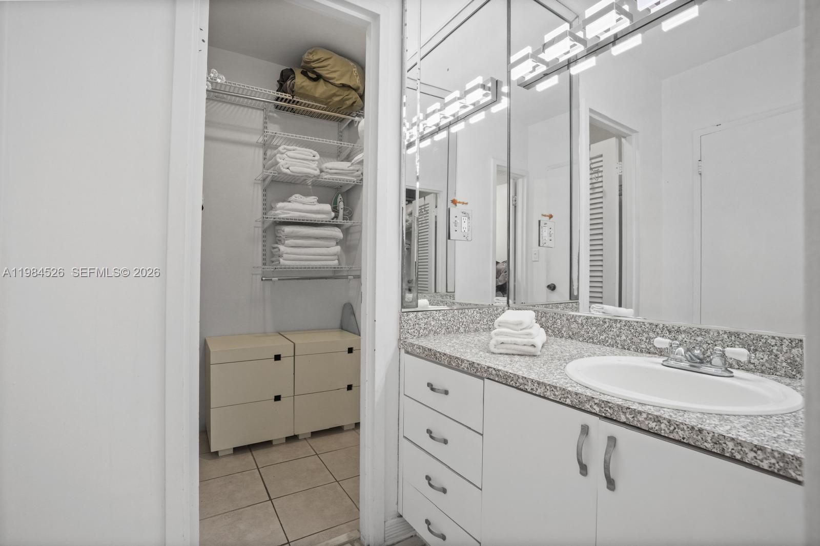 100 Lincoln Road, Unit 825 Miami Beach, FL 33139 - Photo 22 of 51 a bathroom with a granite countertop sink a mirror and a shower