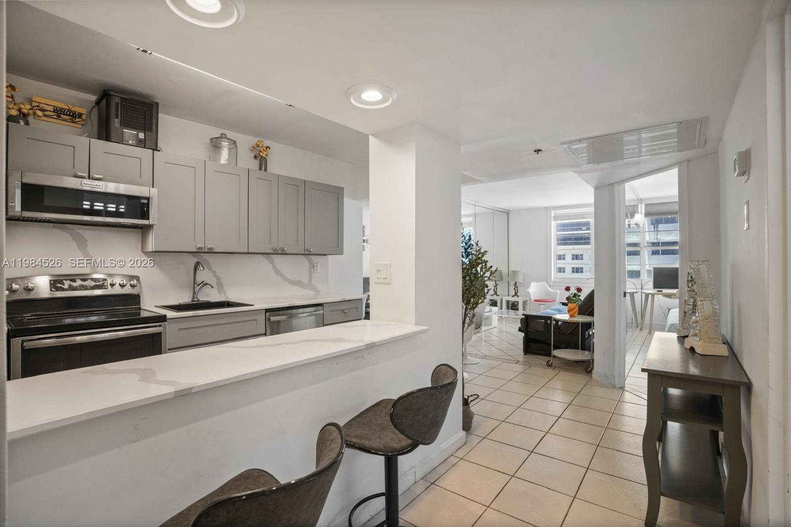 100 Lincoln Road, Unit 825 Miami Beach, FL 33139 - Photo 8 of 51 a kitchen with stainless steel appliances a stove a sink a microwave and cabinets