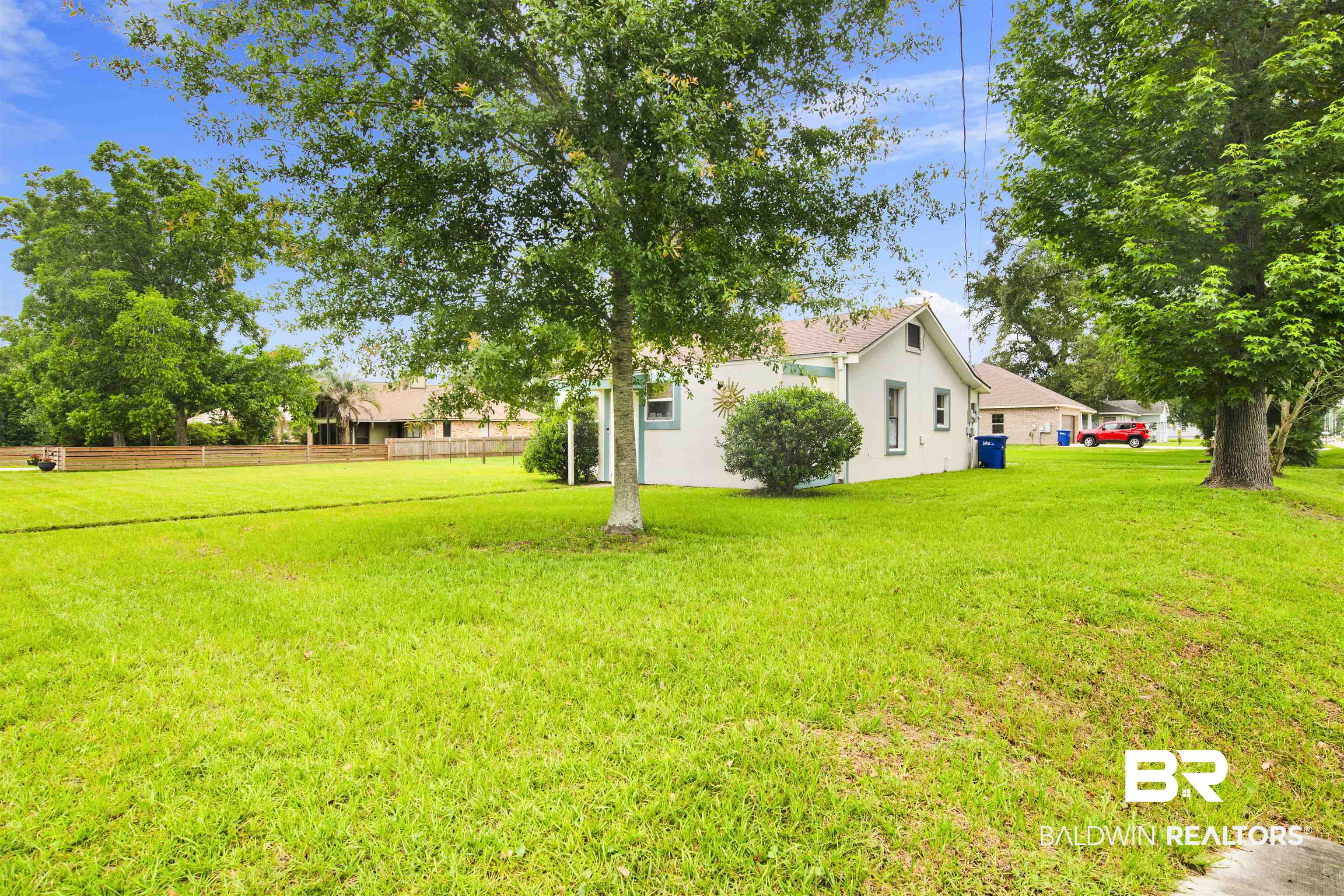 1100 North Pine Street Foley, AL 36535 - Photo 29 of 30 Expansive green lawn with mature trees and a stucco-sided residence