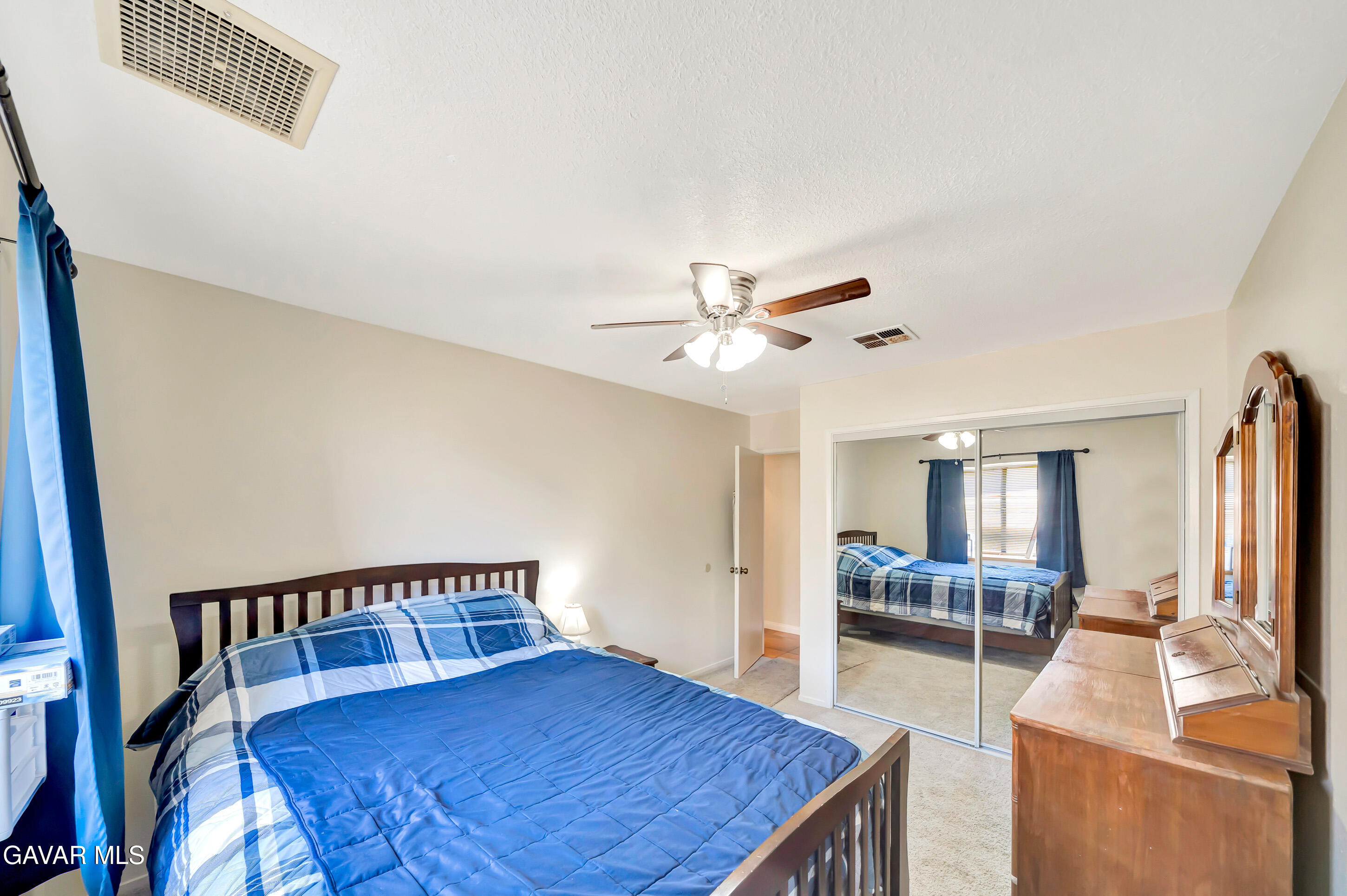 729 North Sunland Drive Ridgecrest, CA 93555 - Photo 37 of 52 a bedroom with a bed and a mirror on a dresser