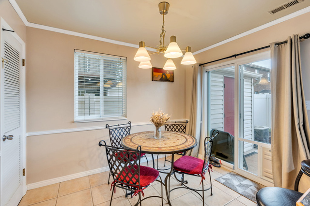1402 South 1470th Street East Provo, UT 84606 - Photo 5 of 21 Dining space with crown molding, light tile patterned flooring, and hanging lights