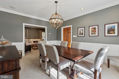 a view of a dining room with furniture a chandelier and wooden floor