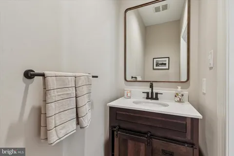a bathroom with a sink vanity and a mirror