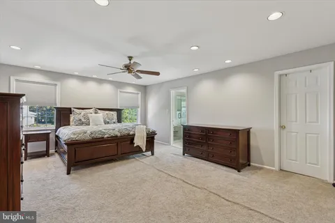 a bed sitting in a spacious bedroom next to a window